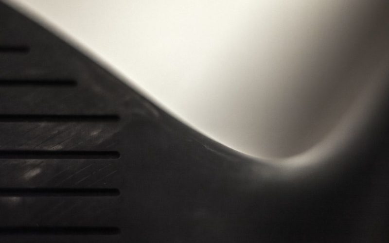 Närbild av en textilyta med diskreta linjer och en kurvig kant.